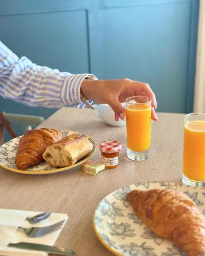a table with plates of pastries and glasses of orange juice at Hôtel La Grande Conque in Cap d'Agde