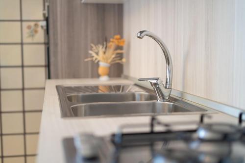 a kitchen counter with two sinks and a mirror at Mandras 1 in La Caletta