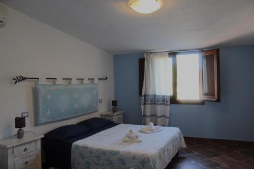 a bedroom with a bed with towels on it at Domo sa prama in Cala Liberotto