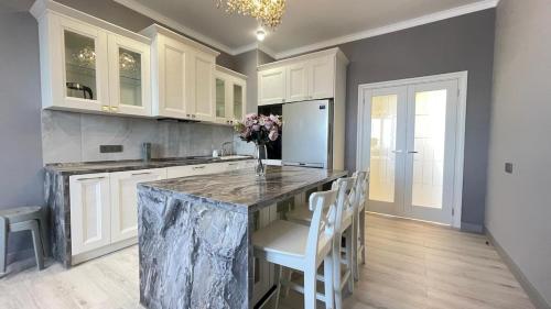 a kitchen with a marble counter top and white cabinets at ЖК Madina in Petropavlovsk