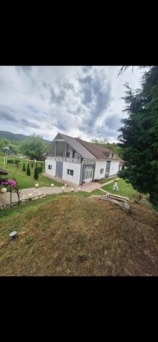 a large white building in a field with a yard at Casa Maria in Costeşti