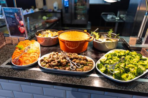 a buffet filled with different types of food on a counter at Clarion Hotel The Edge in Tromsø
