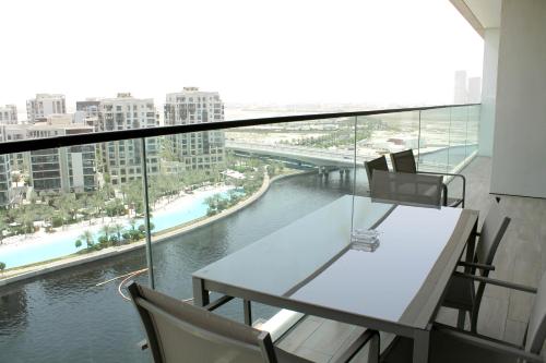 a table and chairs on a balcony with a view of a river at Palace Residences luxurious 2 bedroom with breathtaking views in Dubai