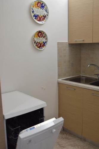 a kitchen with a sink and plates on the wall at Nel borgo di Zia Alma in Cormòns