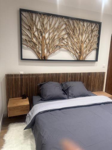 a bedroom with a framed picture of trees on the wall at Ozero in Chindrieux