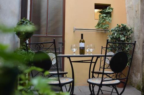 a table with two glasses and a bottle of wine at Nel borgo di Zia Alma in Cormòns