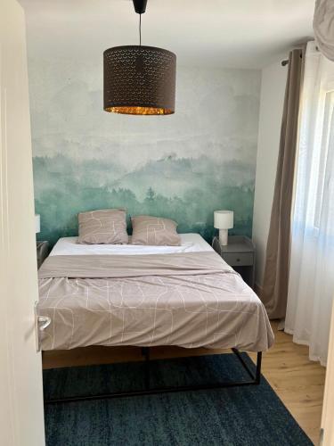 une chambre avec un lit et un tableau au mur dans l'établissement La Maisonnette du Lac, à Novalaise