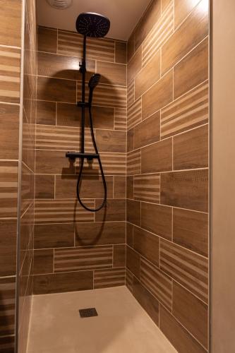 La salle de bains est pourvue d'une douche et de carrelage en bois. dans l'établissement nuit romantique insolite dans une cascade, à Bourg-Argental