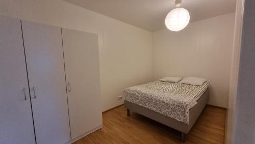 a small bedroom with a bed and a cabinet at Casa 48 in Lahti