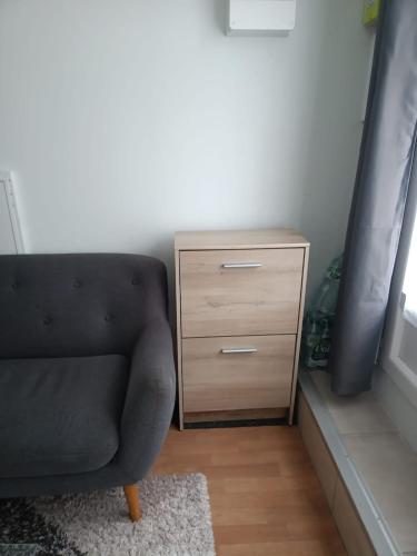 un canapé noir et une commode en bois dans une pièce dans l'établissement Apparemment 2 pièces privé pour vous, à Mantes-la-Ville