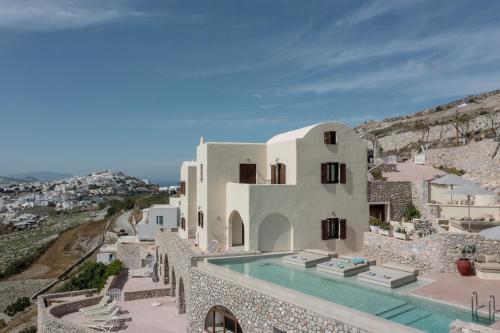 a villa with a swimming pool on a cliff at Zatrikion Santorini Villas in Pirgos