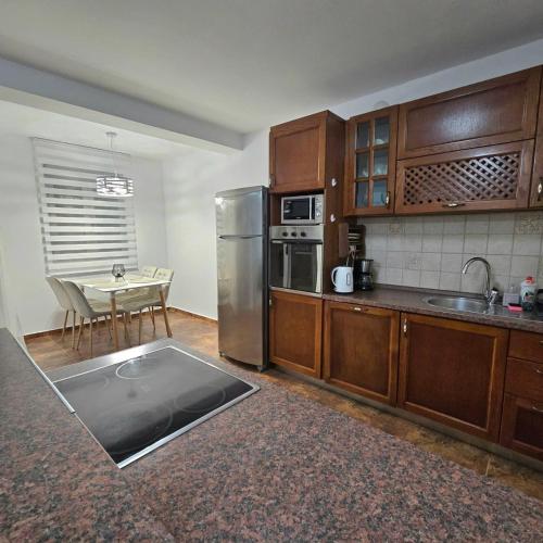 a kitchen with wooden cabinets and a stainless steel refrigerator at LUNA lux in Ðenovići