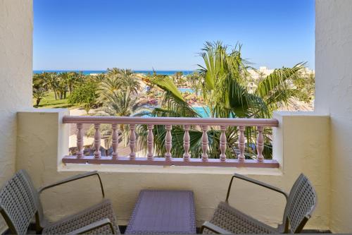 a balcony with chairs and a view of the beach at Les Quatre Saisons Ex Baya Beach in Djerba