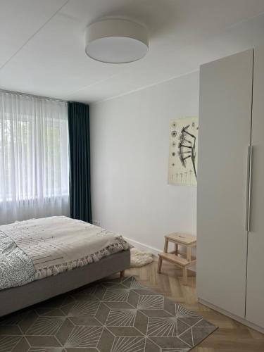 a white bedroom with a bed and a window at Composer's apartment in Tallinn