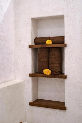 a wooden shelf with towels on a wall at Villa Taman & Villa Serai Kedungu in Tanah Lot