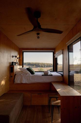 une chambre avec un lit et une grande fenêtre dans l'établissement Parcel Tiny House Cave Nerot, au coeur des vignes près de Sancerre, à Saint-Père