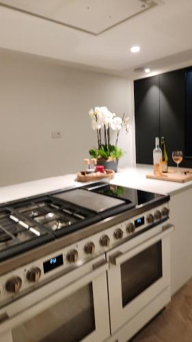a kitchen with a stove top oven in a kitchen at Villa Namasté SPA Hammam port & Mer in La Trinité-sur-Mer