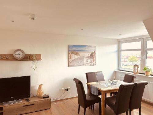 a dining room with a table and chairs and a tv at Ferienwohnung im Hotel Preyt 35228 in Holtlander Nücke