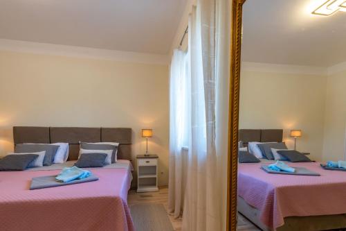 NedeščinaにあるVilla Casa Berton, a charming pool villa close to the seaの鏡付きの部屋にベッドが2つある