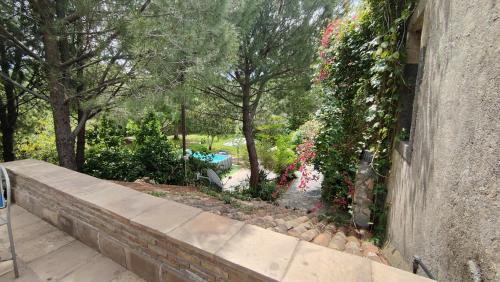 a stone retaining wall with flowers and a garden at Agriturismo Boccadifuoco in Motta Camastra
