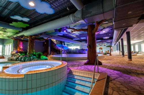 a water park with a tree and a hot tub at Vakantiepark BreeBronne in Maasbree