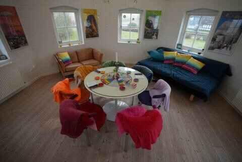 a living room with a table and chairs at Relax In Scenic Surroundings in Østbirk