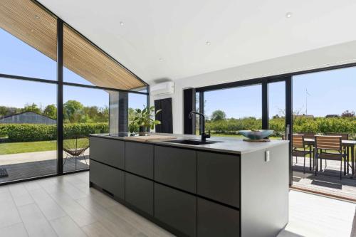 a kitchen with a sink and large windows at Modern Holiday Home On Beautiful Langeland in Humble