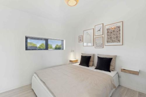 a white bedroom with a bed and a window at Modern Holiday Home On Beautiful Langeland in Humble