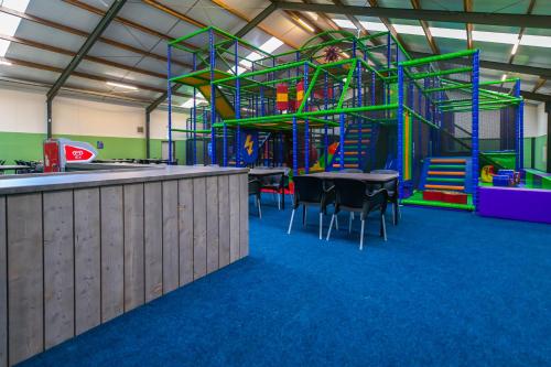 a gym with a playground with tables and chairs at Vakantiepark BreeBronne in Maasbree