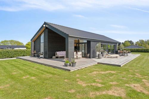 a small house with a deck in a yard at Modern Holiday Home On Beautiful Langeland in Humble