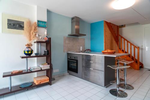 - une cuisine avec un comptoir, un évier et une cuisinière dans l'établissement Locmariaquer Mer & Plage - à 50m de la plage, à Locmariaquer