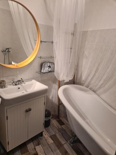 une salle de bain avec une baignoire, un lavabo et un miroir dans l'établissement tout près du canal royal et des halles, à Sète