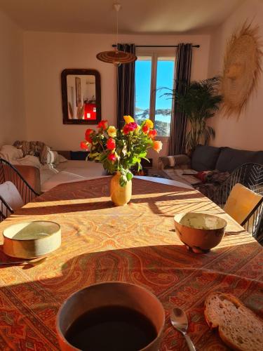 un salon avec une table avec des fleurs dessus dans l'établissement tout près du canal royal et des halles, à Sète