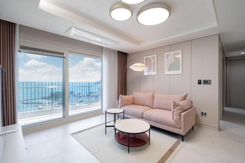a living room with a couch and a table at Le Collective Busan Gijang in Busan