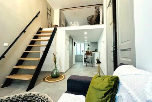 un salon avec un escalier et un canapé dans l'établissement La loge romaine - centre ville - clim, à Nîmes