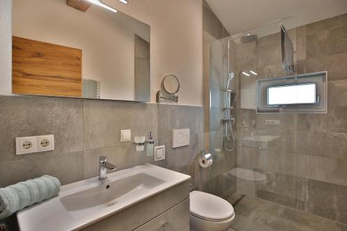 a bathroom with a sink and a toilet and a mirror at Apart Auszeit in Wenns