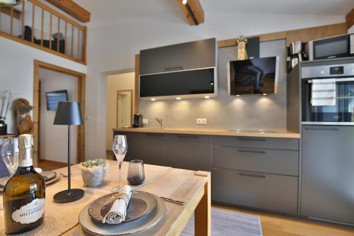 a kitchen with a table with a bottle of wine at Apart Auszeit in Wenns