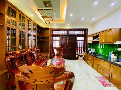 a large kitchen with wooden cabinets and a table at BIỆT THỰ NGHĨ DƯỠNG CAO CẤP THUỲ VÂN BÃI SAU VŨNG TÀU-Mt VƯƠNG VILLA in Vung Tau