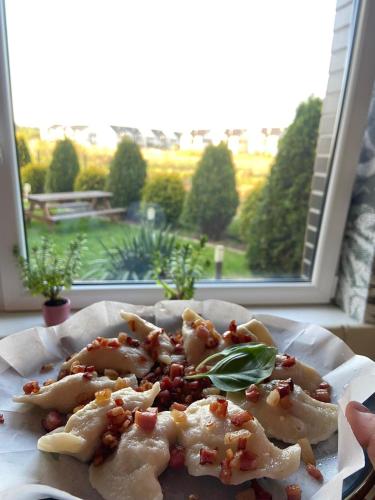 un plato de comida en una mesa frente a una ventana en Sleepinn Gdansk Airport, en Gdańsk-Rębiechowo