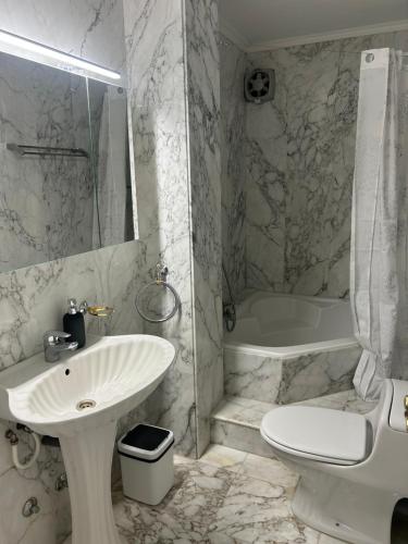 a bathroom with a sink and a toilet and a tub at Schönes Apartment - ruhig - Aussenpool in La Orotava