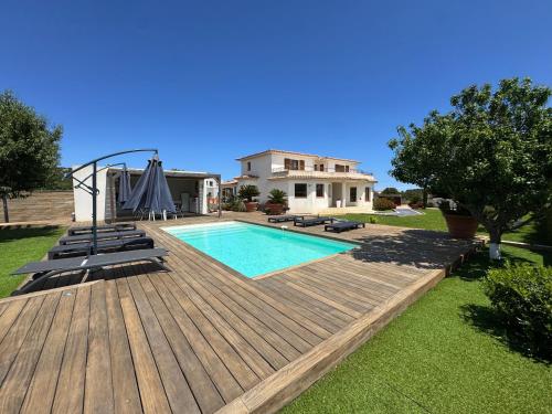 une maison avec une piscine et une terrasse en bois dans l'établissement Villa avec piscine à Lecci, à Lecci