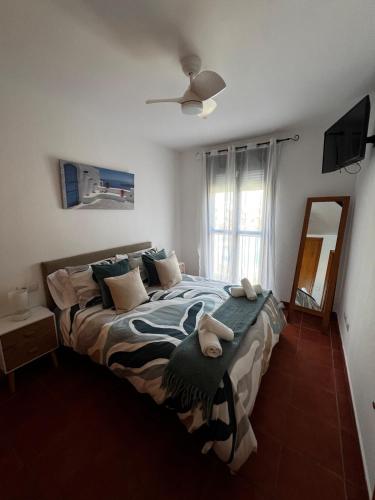a bedroom with a large bed with towels on it at Apartamento Riviera in Novo Sancti Petri