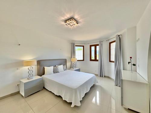 - une chambre blanche avec un lit et deux lampes dans l'établissement Villa avec piscine à Lecci, à Lecci