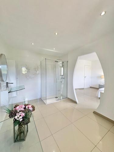 La salle de bains est pourvue d'une douche et d'un vase de fleurs. dans l'établissement Villa avec piscine à Lecci, à Lecci