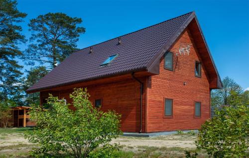 a large wooden barn with a black roof at Stunning Apartment In Ostrowite in Ostrowite