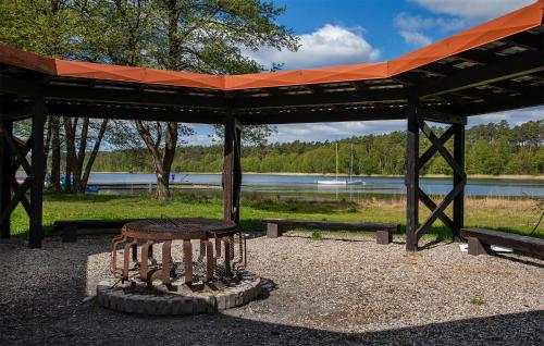a bench sitting under a pavilion next to a lake at Amazing Home In Ostrowite With Sauna in Ostrowite