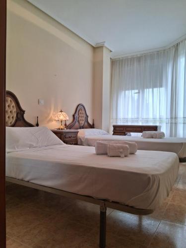 a bedroom with two beds and a window at R2R - Apartamento en Noja 2 dormitorios - C18A02 in Noja