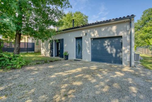 a garage building with a large garage door at La belle escapade-6 personnes- piscine in Puymoyen
