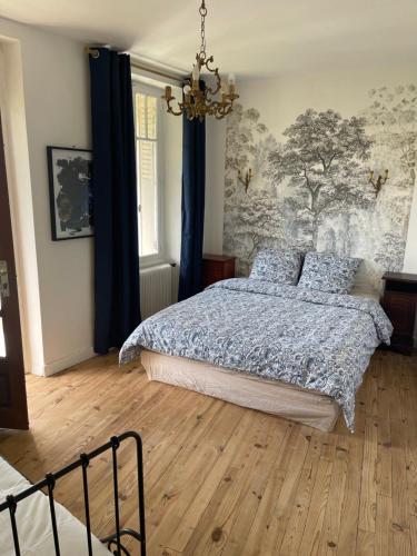 a bedroom with a bed and a chandelier at Maison au cœur de ville in Bort-les-Orgues