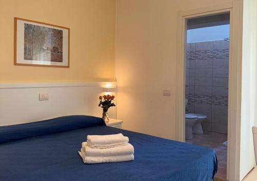 a bedroom with a blue bed with towels on it at Hotel Riviera Nuova Gestione in Cattolica